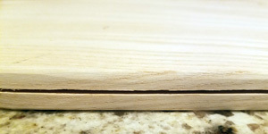 A wooden basket base with a slot cut into the edge